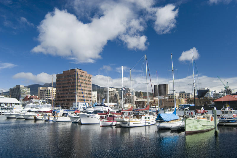 boats moored in a marina with downtown hobart in the background